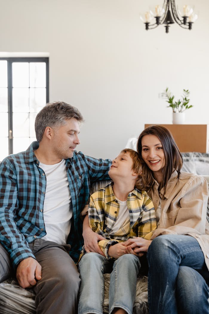 A joyful family sitting together while unpacking in their new home living room.